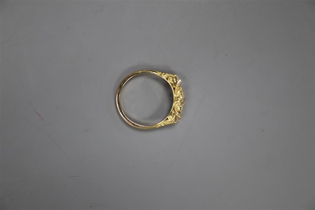 A Victorian style yellow metal and three stone diamond ring with diamond chip spacers, size Q, gross 4.5 grams.